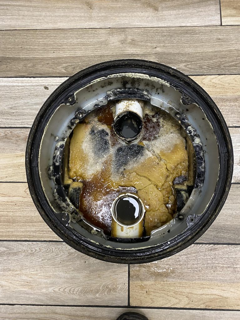 Commercial grease trap filled with grease showing a broken which needs baffle t repair