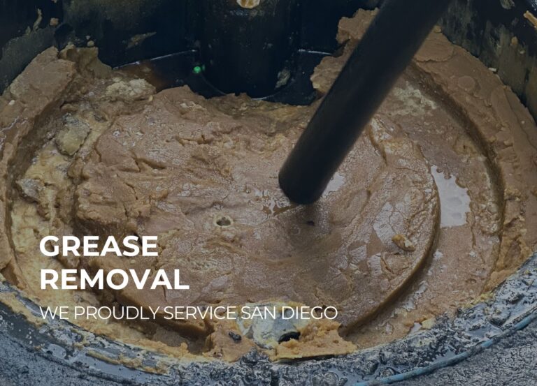 Technician performing emergency grease trap pumping at a commercial kitchen in San Diego County.
